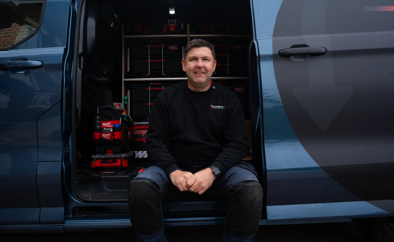 George Campbell of My Energy Pro sitting in the side door of his van, with his tools racked behind him